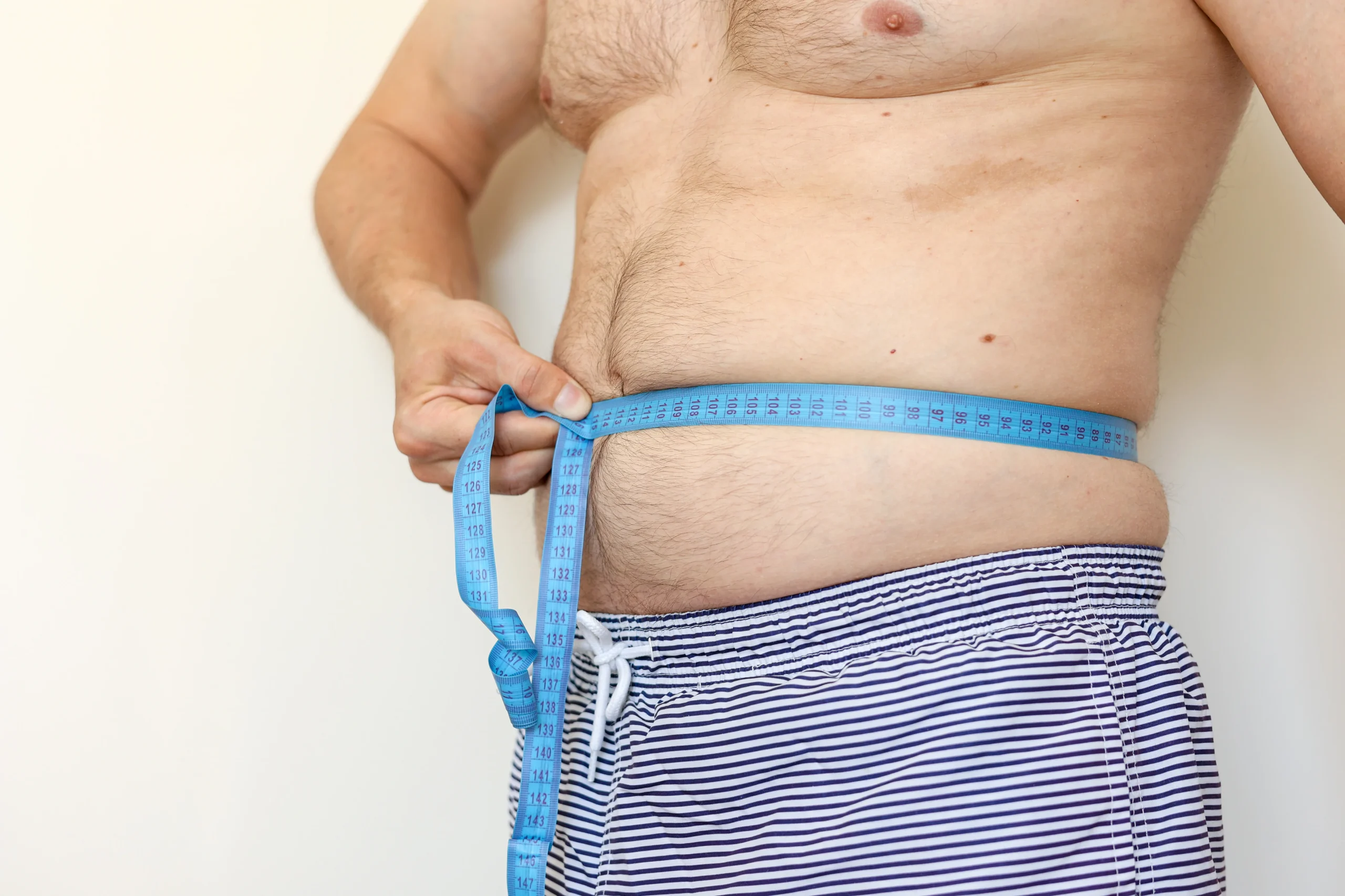 Hombre que está midiendo su tripa.